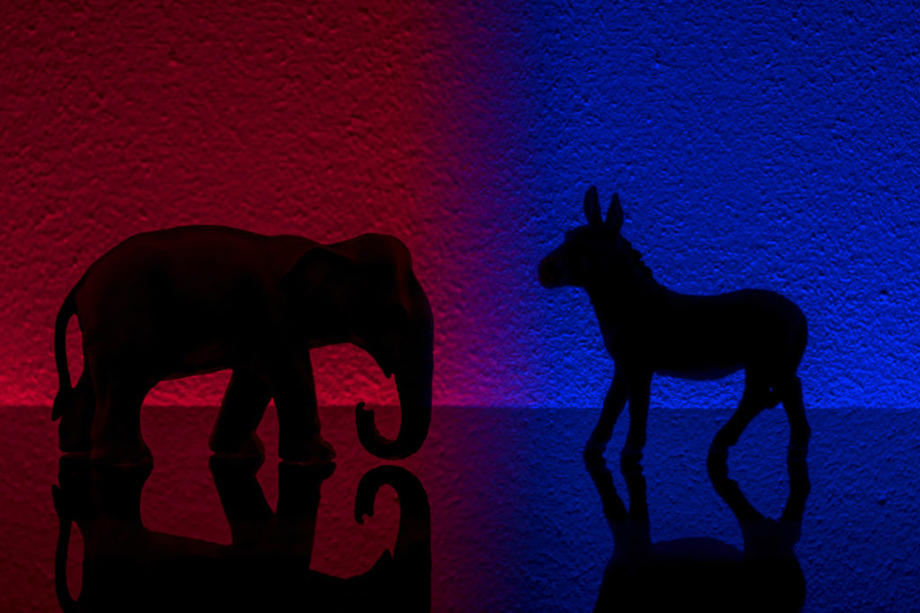 Democrats vs republicans are facing off in a ideological duel on blue and red backgrounds.