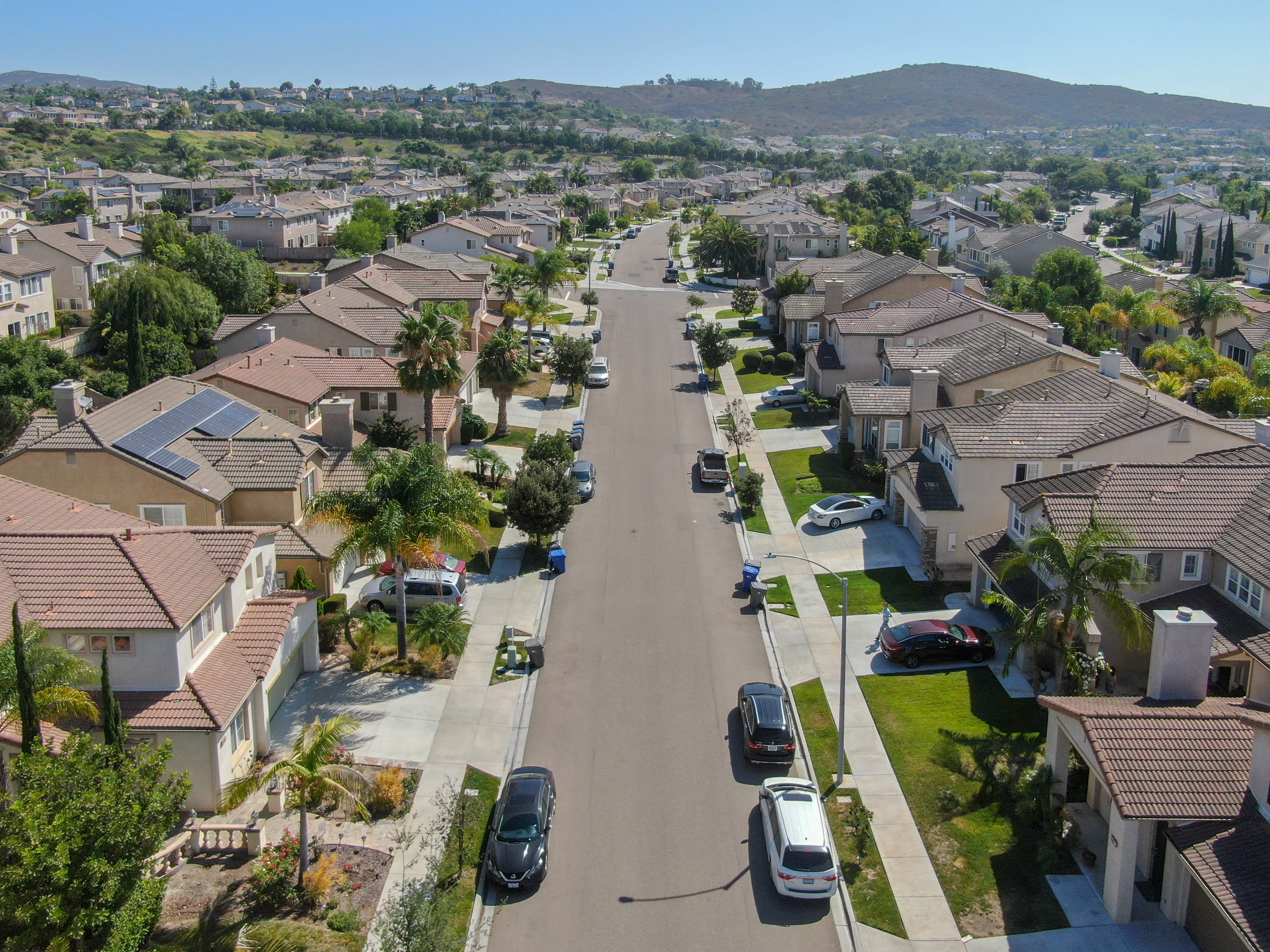 Suburban neighborhood street with big villas next to each other in southern California. Aerial view of residential modern subdivision house.